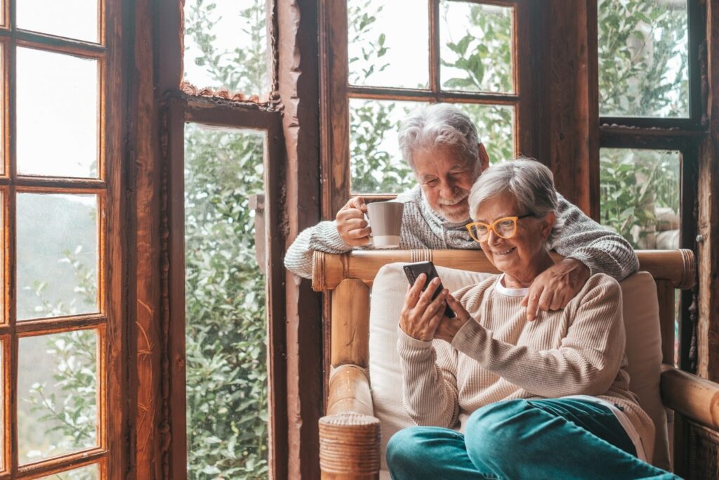 couple of two old and mature people at home using phon
