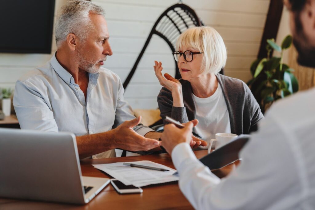 financial advisor giving retirement advice to old couple while they arguing at home interior 1536x1025 1 1024x683 1